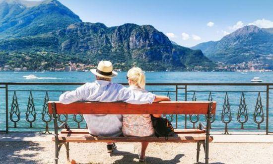 Lake Como, village Bellagio, Italy. Senior couple weekend getaway having rest on the bench by spectacular lake Como in Italy. Sunny day scenery. (1).jpg